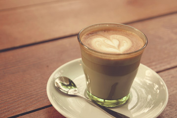 Coffee latte art on the wood texture background - Vintage effect
