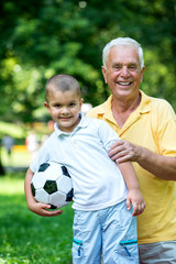 Naklejka premium grandfather and child have fun in park