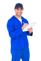 Portrait of happy male mechanic writing on clipboard