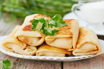 Fototapeten Stuffed pancakes crepes with meat and sauce © irrez