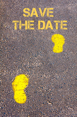 Yellow footsteps on sidewalk towards Save the Date message
