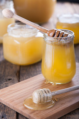 Honey in a jar with a wooden honey dipper.