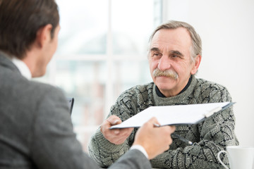Businessman having an interview with smiling old man