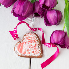 Heart shaped cookie decorated with ornaments and flowers.