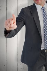 Composite image of businessman pointing with his finger