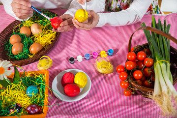 Close up of little girl and mother coloring eggs for Easter