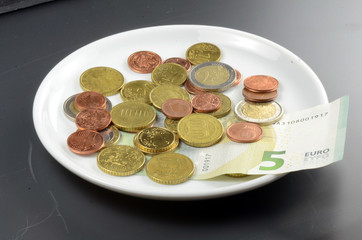 Münzen auf Teller