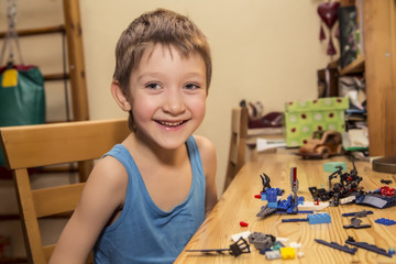 Littleboy smiling, interesting, holding a colorful Bricks