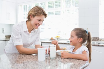 Obraz na płótnie Canvas Mother and daughter having breakfast