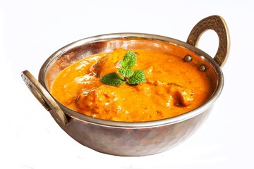 Chicken tikka masala served in a kadai on white background