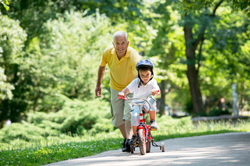 grandfather and child in park using tablet