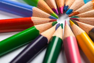 Fototapeta premium Several color pencils on a white paper sheet