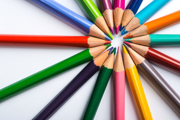 Naklejka premium Several color pencils on a white paper sheet