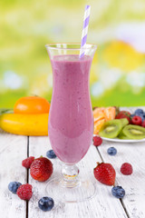 Delicious berry cocktail on table on bright background