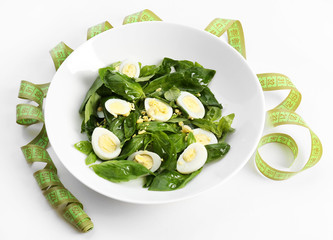 Salad with quail egg and basil in plate isolated on white