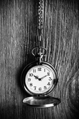 Silver pocket clock on wooden background