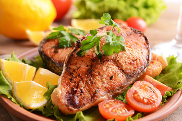 Tasty baked fish on plate on table close-up