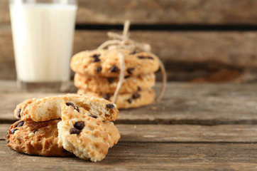 Tasty cookies and glass of milk on rustic wooden background