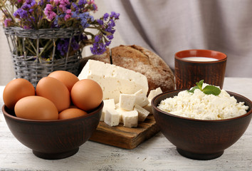 Tasty dairy products with bread and dry flowers