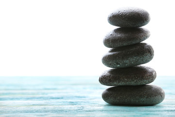 Spa stones with water drops on table on light background