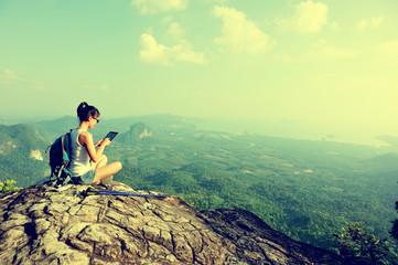 young woman hiker use digital tablet at mountain peak