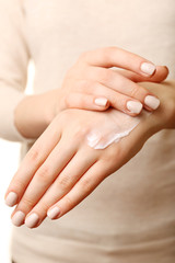Obraz na płótnie Canvas Female applying cream on her hand, closeup