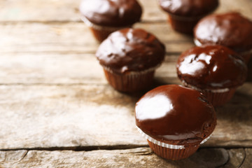 Tasty homemade chocolate muffins on wooden table