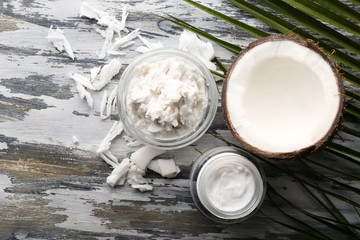 Coconut with coconut oil in bowl with jar of cosmetic cream