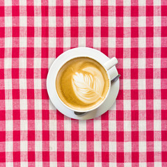 cappuccino coffee on white and red checkered background close up