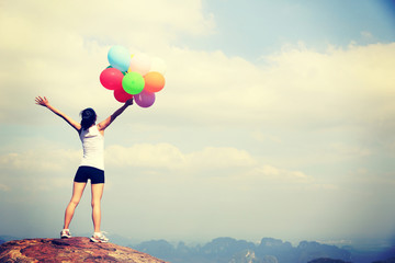 young asian woman mountain peak  with colored balloons 