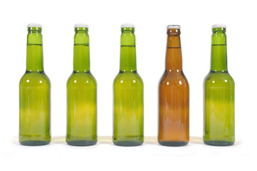 Row or line of green blank beer bottles with one unique brown bottle photo