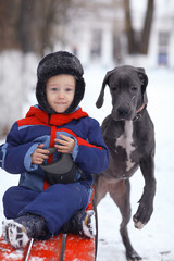 little boy with a big black dog breed