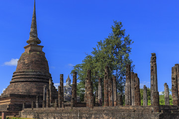 Obraz premium Ancient Buddha statue and pagodas at Sukhothai Historical Park,
