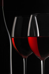 Wine glass and bottle silhouette on black background