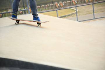 skateboarder legs skateboarding at skatepark ramp 