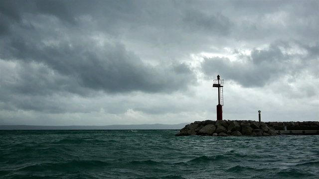 Port entrance with beacon and storm coming in background