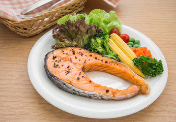 Grilled salmon steak with vegetables on plate