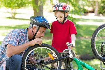 Naklejka premium Father and son fixing a bike