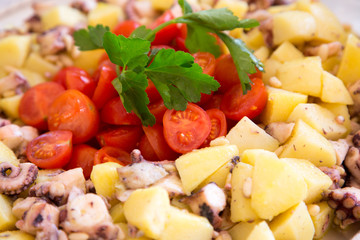 Pomodorini, polpo e patate in primo piano