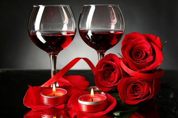 Composition with red wine in glasses, red rose and decorative