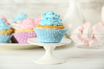 Delicious cupcakes on table on light background