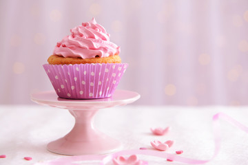 Sweet cupcake on table on light background