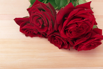 Beautiful roses on wooden table background