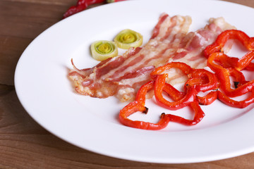 Strips of bacon with sliced shallot and pepper in plate
