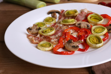 Strips of bacon with sliced shallot and pepper in plate
