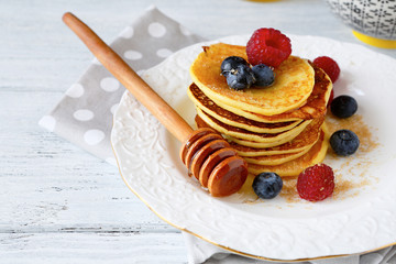 Pancakes with berries on a white plate