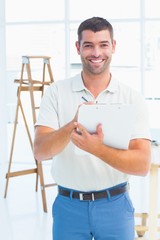 Smiling handyman writing on clipboard at construction site