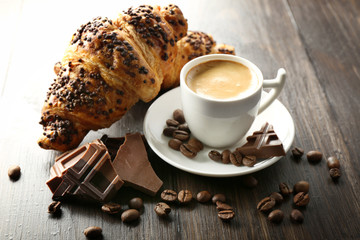 Fresh and tasty croissants with chocolate and cup of coffee