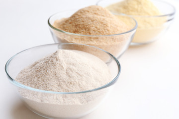 Different types of flour in bowls isolated on white