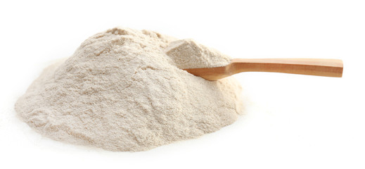 Heap of flour with wooden spoon isolated on white